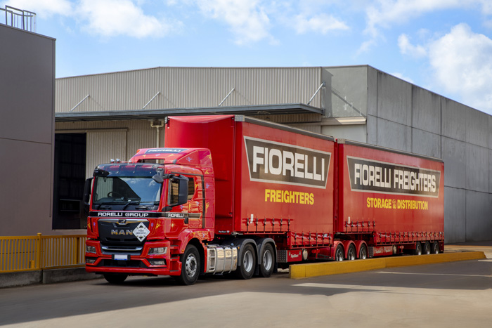 A long red truck with Fiorelli Freighters signage on the side is parked at the weighbridge.